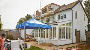 The rear of a client's white rendered house mid-construction, with scaffolding around a loft and rear extension delivered by Maidenhead Planning.