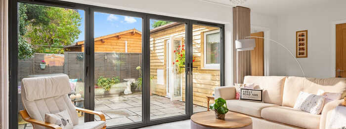 Cozy living room with large windows, a sofa, and a view of the outdoors.