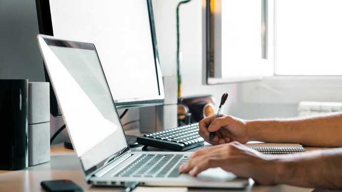 person working from home, on a laptop at a desk