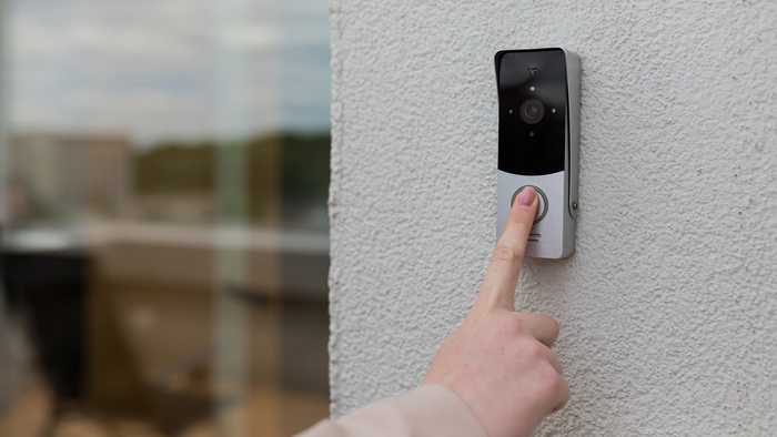 Person pressing video doorbell