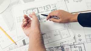 Architectural plans for a home extension spread out during an early design discussion