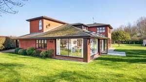 Single storey garden room extension with a tiled roof and large glazing on a red brick house in Pinkneys Green