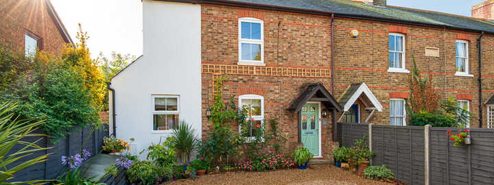 Cozy living room with large glass doors, sofa, armchair, and outdoor view.