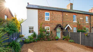 Charming Maidenhead Cottage with extension, a garden and gravel driveway in sunny weather.