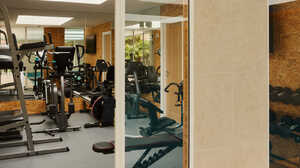 Bright dining area with a wooden table, blue chairs, and large glass windows overlooking a garden.
