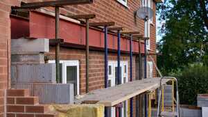 Rear extension build with a red steel beam on props, new blockwork and brick walls