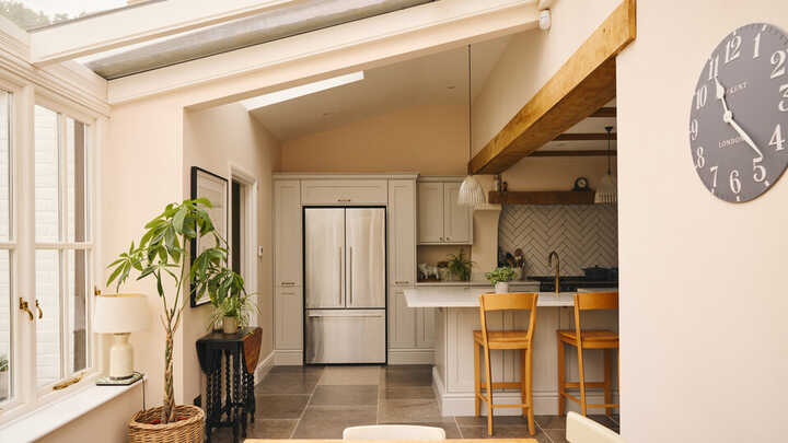Bright kitchen with a dining table, modern appliances, and a large skylight.